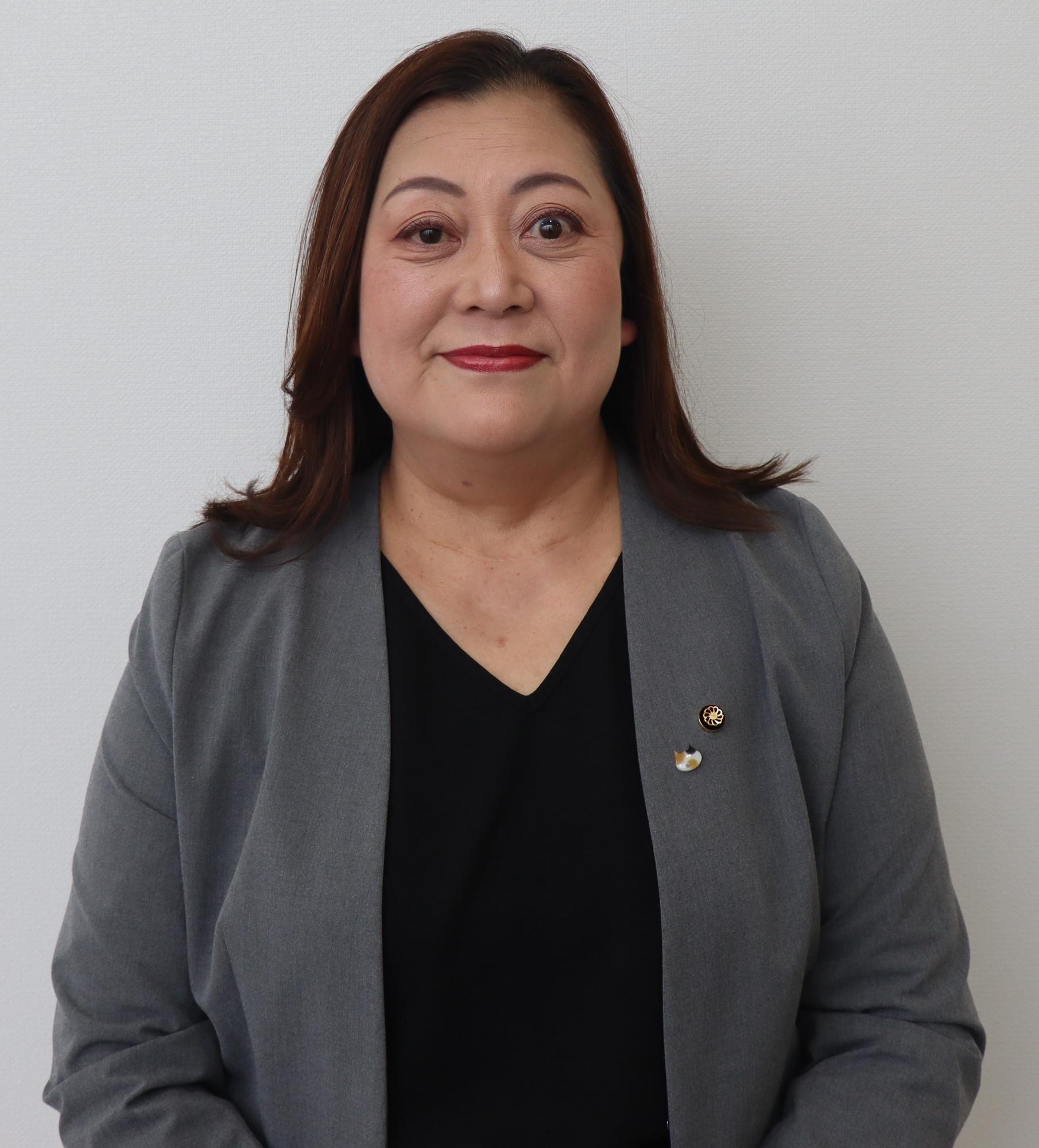 グレーのスーツ姿の女性、石川 恵美（いしかわ えみ）の写真