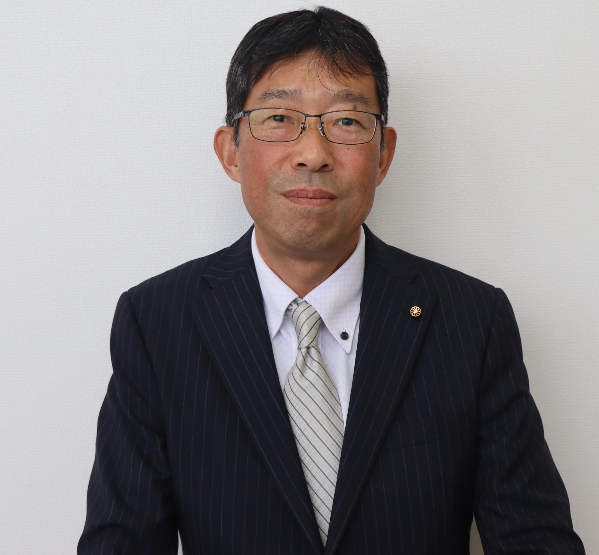 黒いスーツ姿の男性、木下 伸一（きのした しんいち）の写真