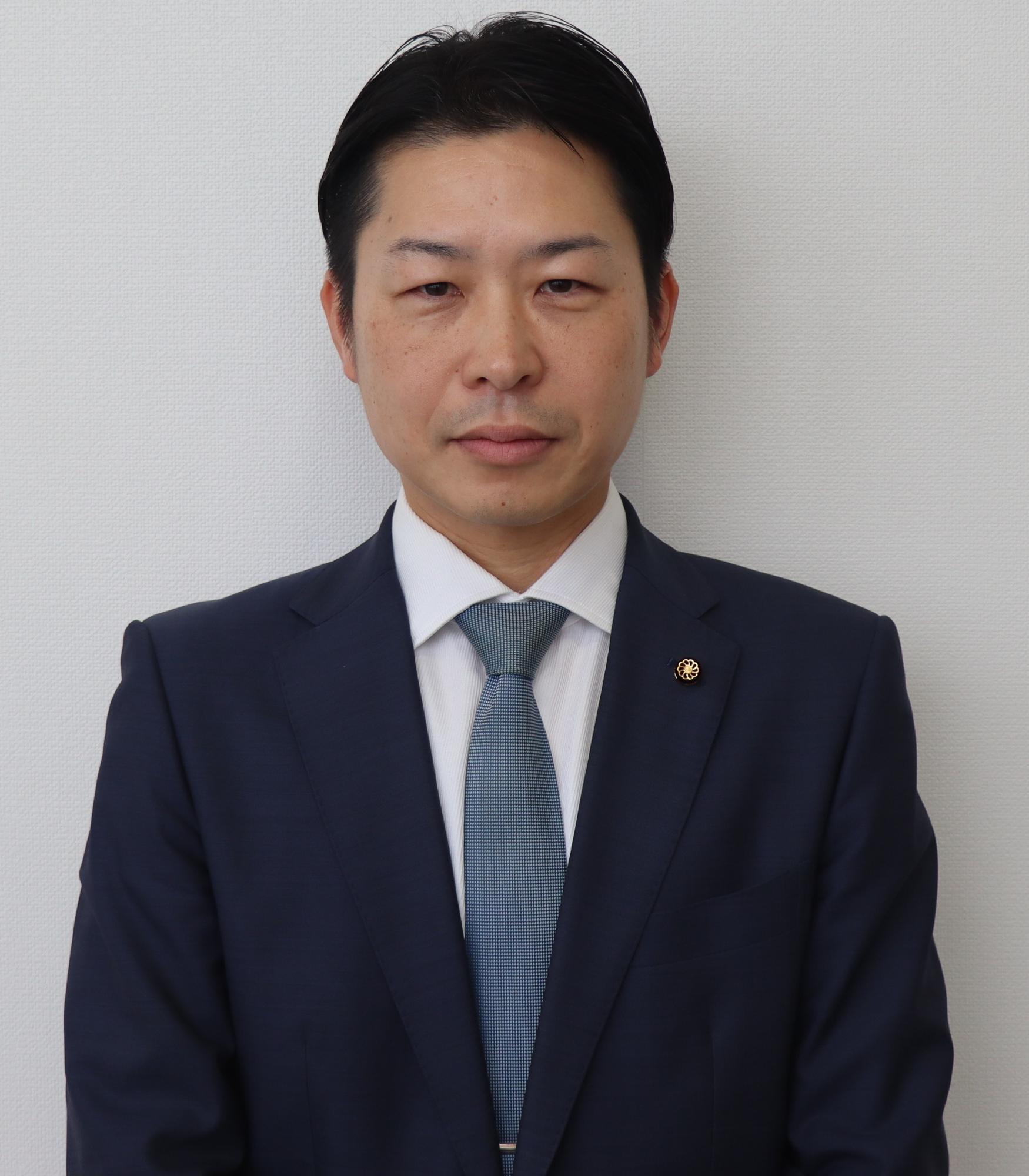 紺色のスーツ姿の男性、益川 教智（ますかわ のりとも）の写真