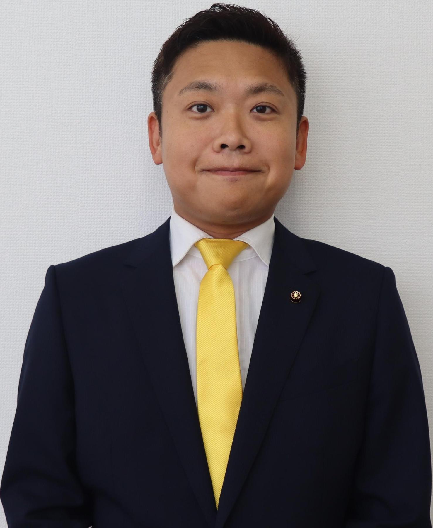 黒いスーツ姿の男性、田中 遼（たなか りょう）の写真