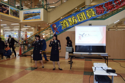 制服を着用した2人の女性がマイクを手に持って並んでいる写真