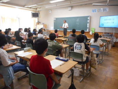 弁護士の講師が教室内で椅子に座る児童たちに、いじめについての講義をしている写真