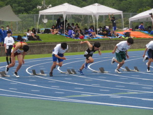 屋外の広いグラウンドのようなところでユニフォームを着た複数の選手がスタートを切る写真